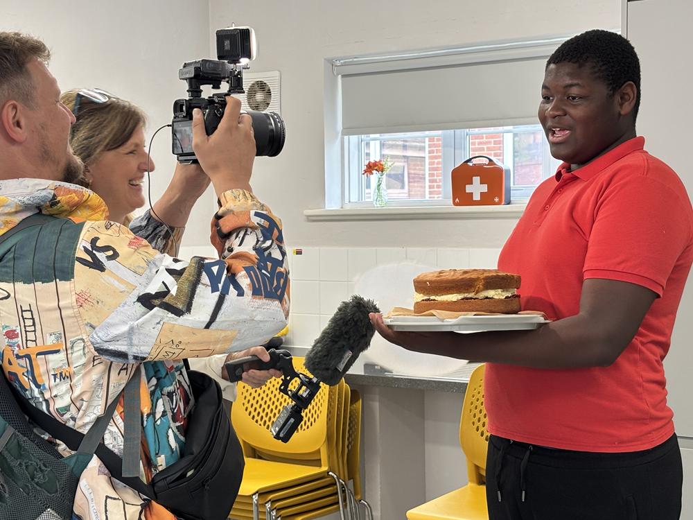 a journalist interviews a pupil about their bake
